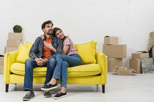 couple is waiting for house moving on a sofa